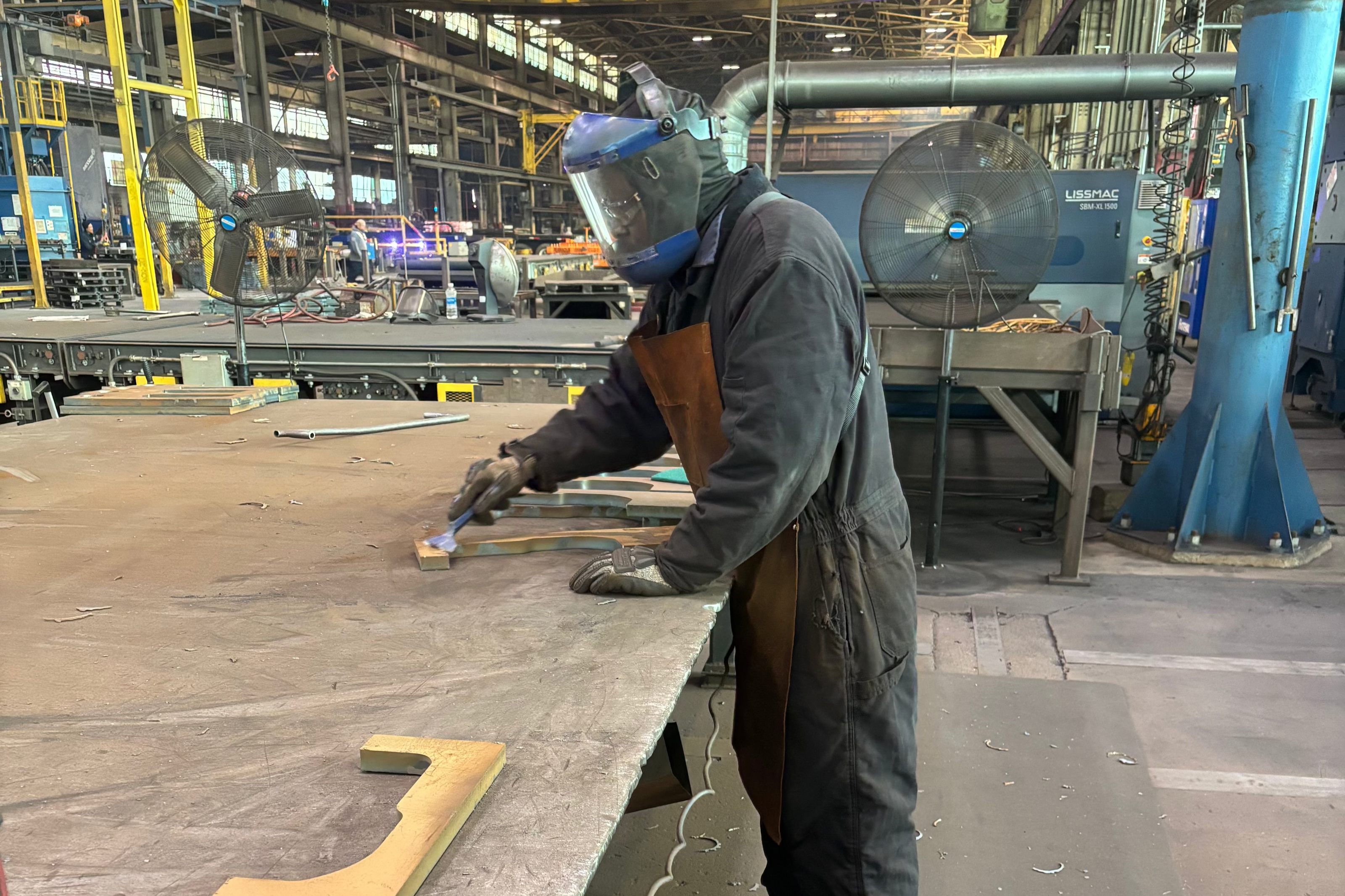 Man working in an industrial warehouse wearing industrial safety gloves, durable industrial work gloves and shop gloves with ANSI impact protection.